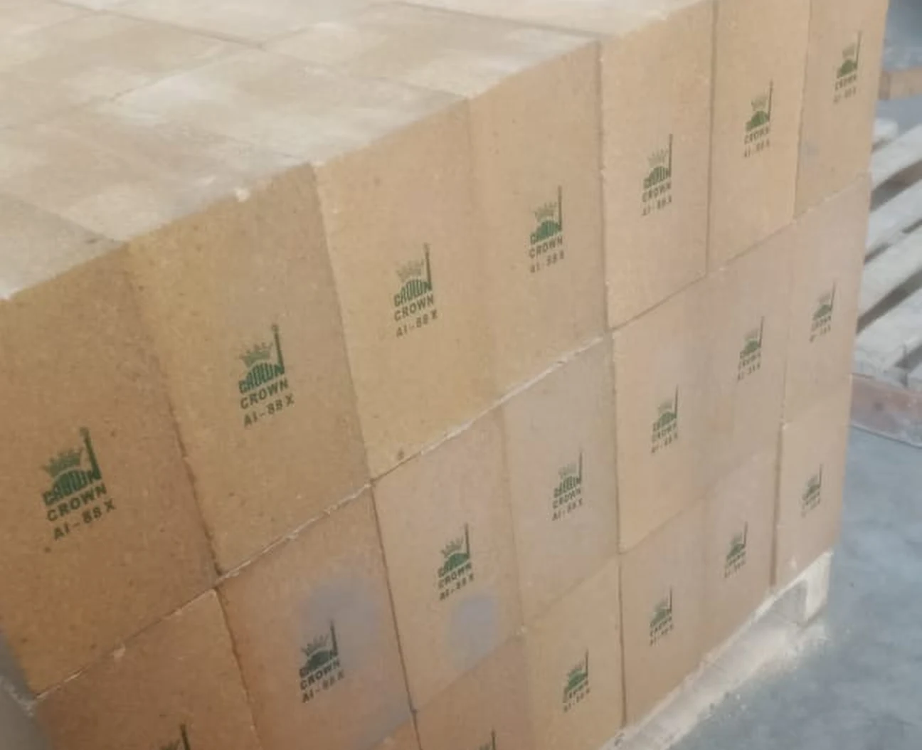A palletised stack of Crown AI-88X hearth blocks at the Wankaner works, each stencilled in green with the Crown mark and grade