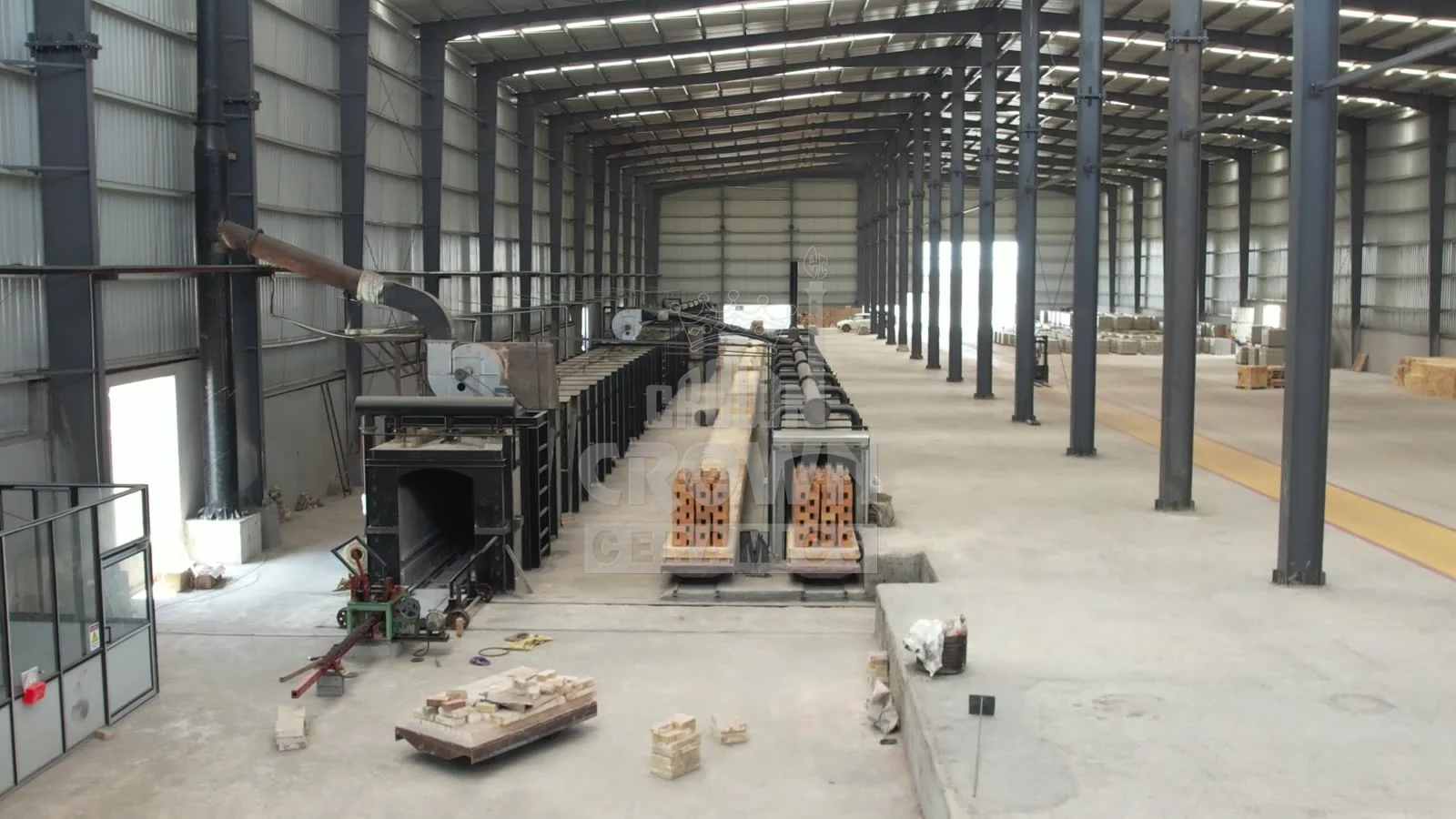 Tunnel kiln hall at Crown Ceramics with loaded kiln cars entering the kilns